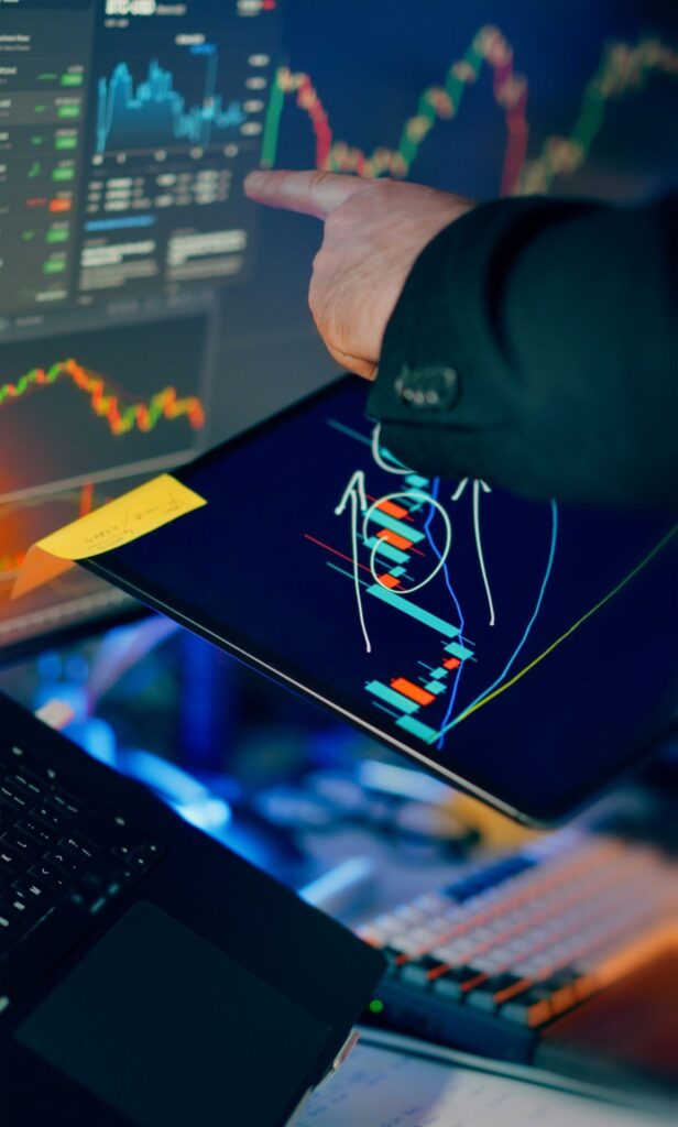 Trader reviewing financial charts on multiple screens before making a trading decision.